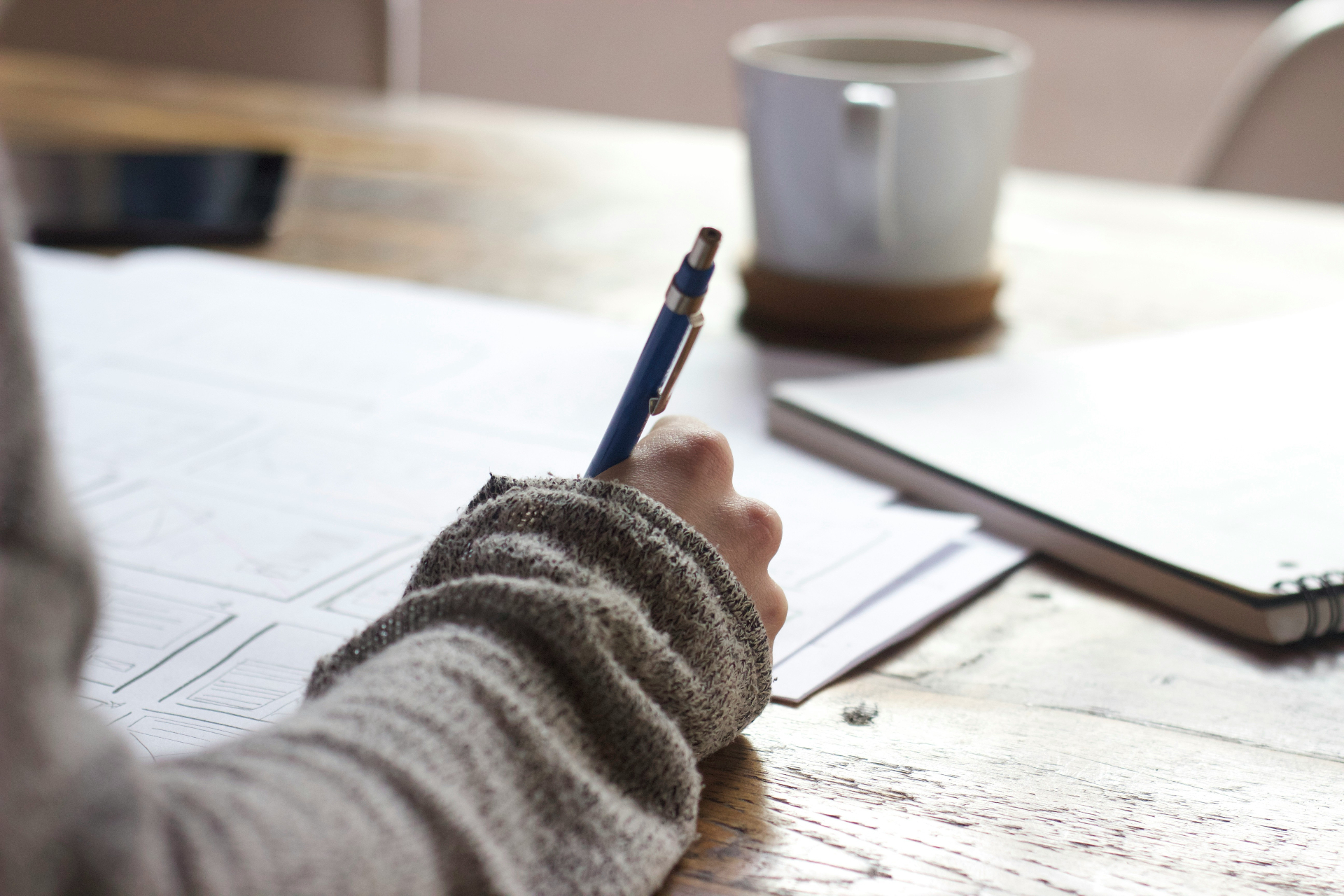 Person writing notes at a desk.