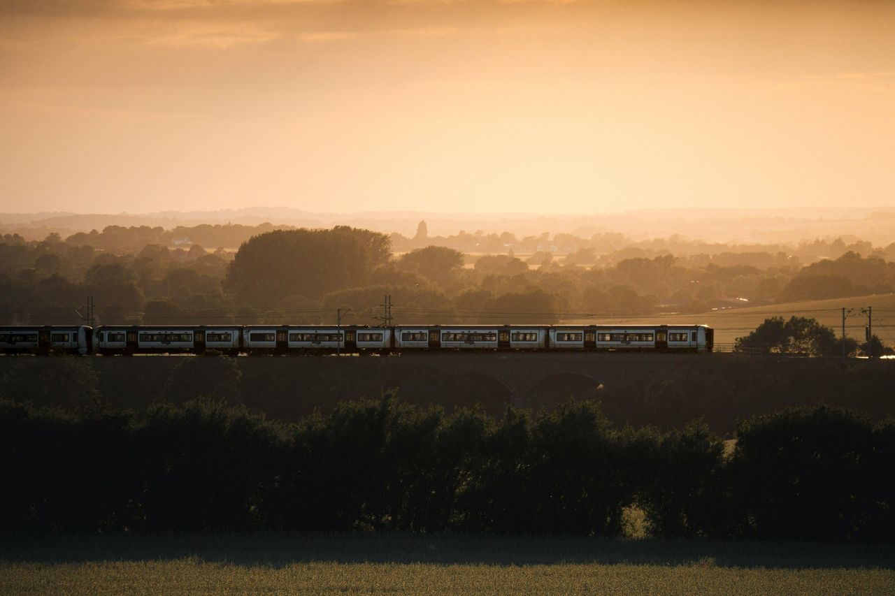 A train crossing the English countryside at sunset.